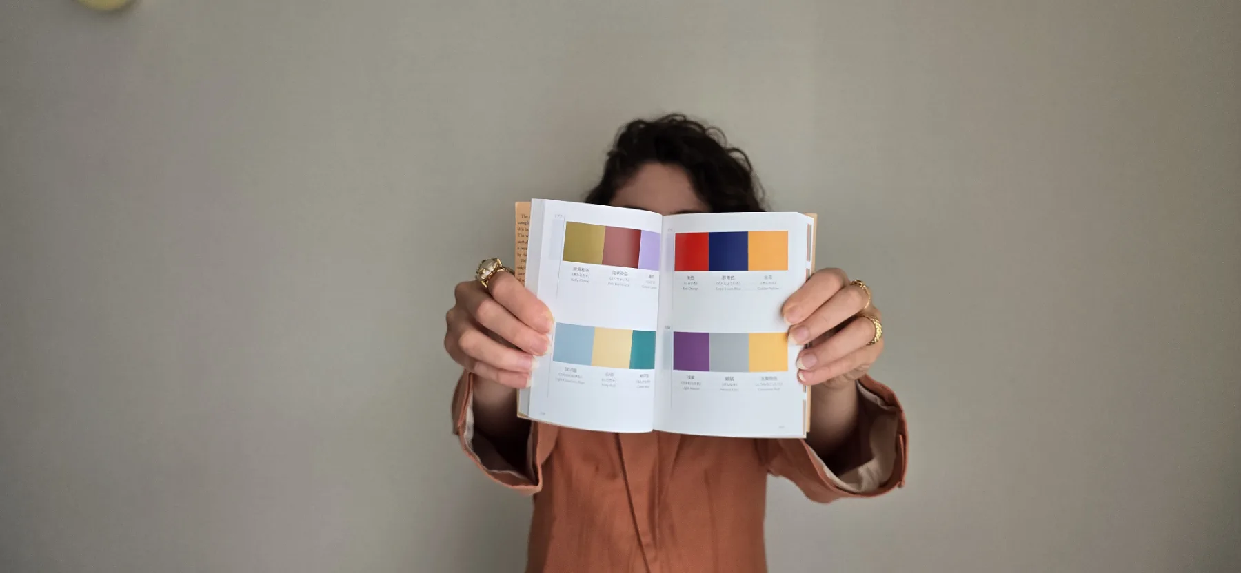 Simona mostra un libro aperto con diverse palette cromatiche